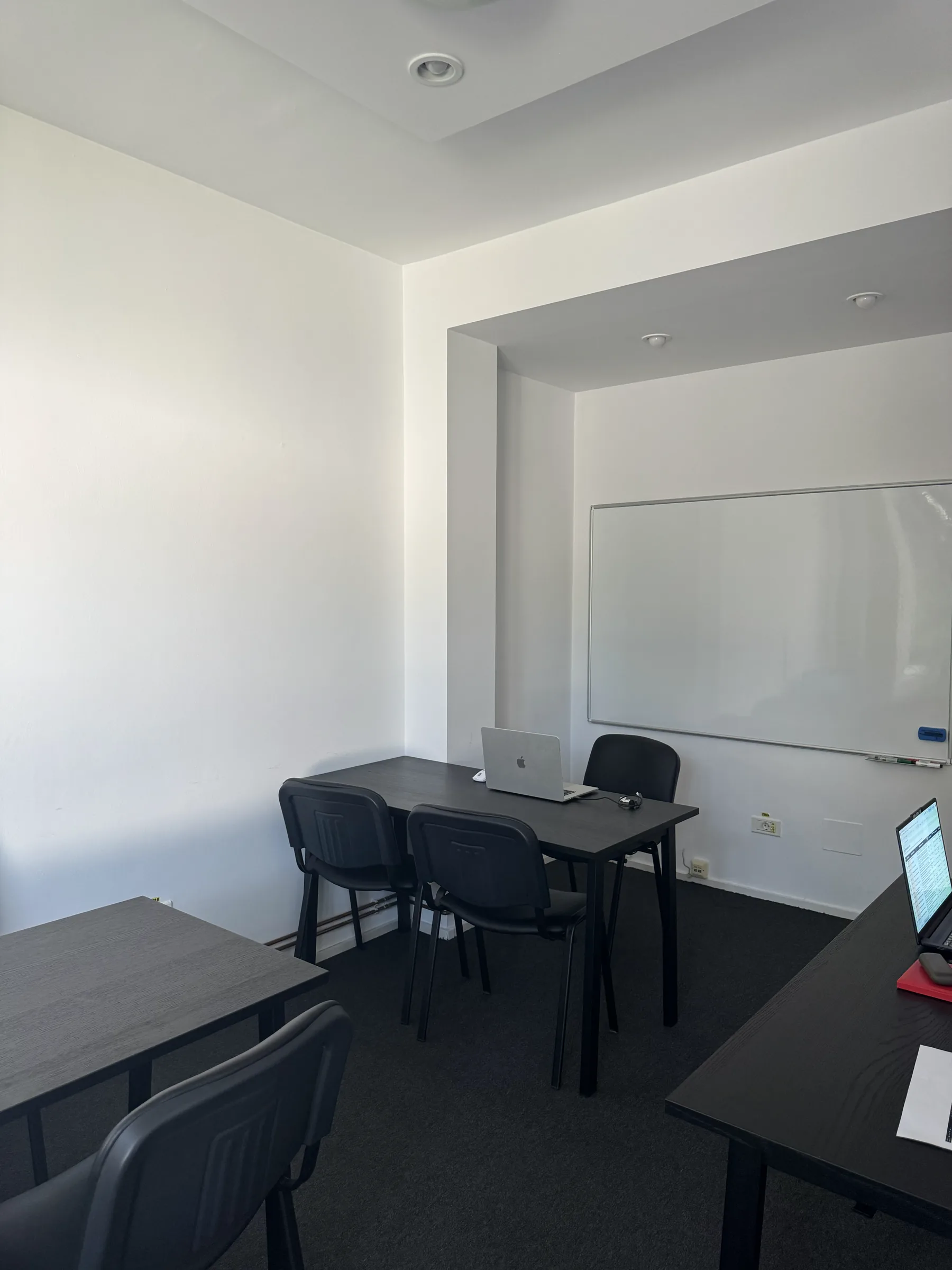 Sala 2 privită dinspre colț, cu tabla albă și masa de lucru