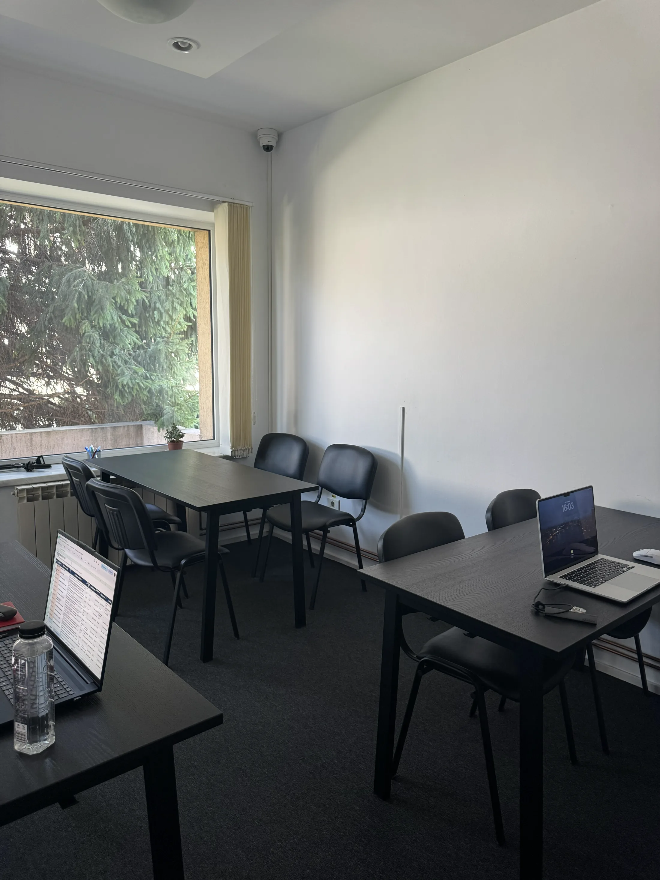 Sala 2: masa lungă cu scaune, geamul cu verdeață în stânga și birourile laterale