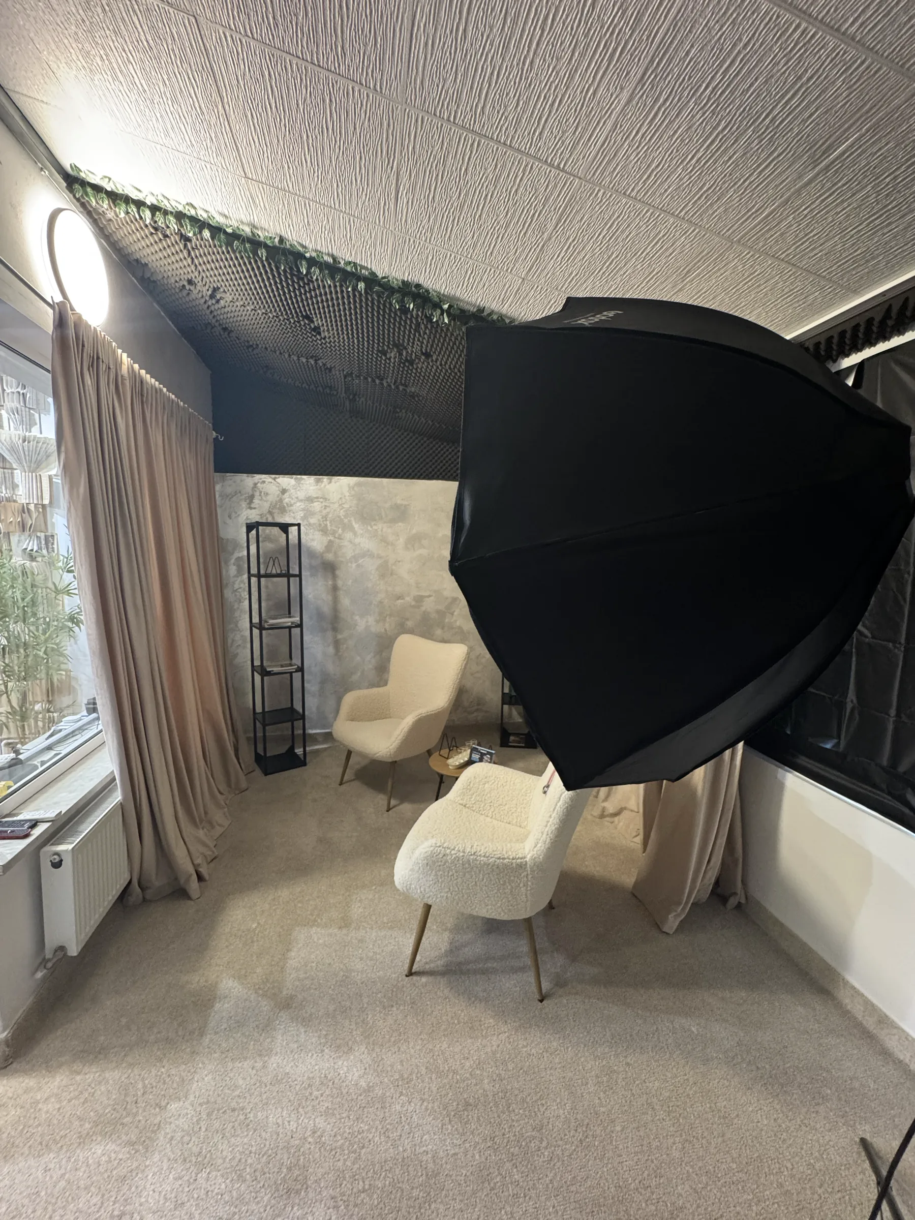 Colțul de interviu din alt unghi, cu softbox-ul în prim-plan și tavanul acustic deasupra